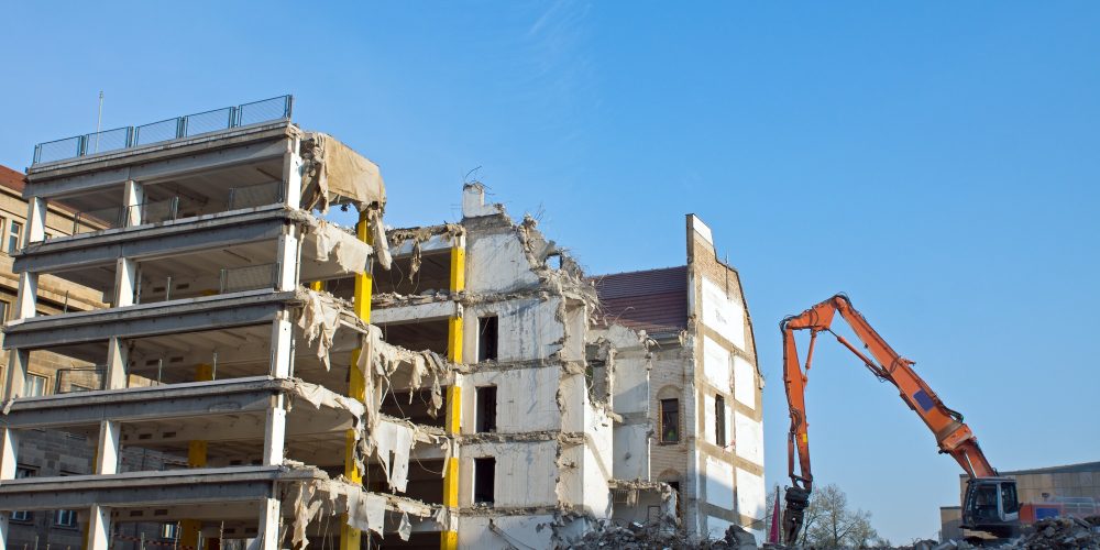demolition-of-a-building-with-excavator-PGKHBSN